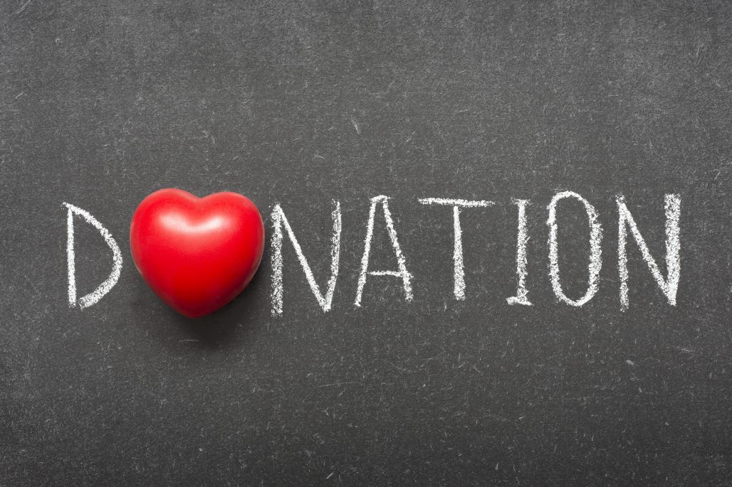 donation word handwritten on school blackboard with heart symbol instead of O